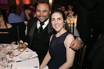 A couple at their table smiles for the camera