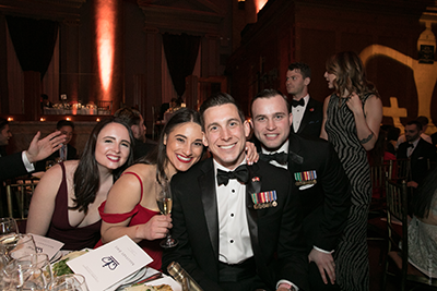 Four attendees smile for the camera at their table