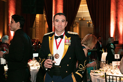 A decorated military veteran mingles with guests before dinner