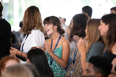 a students stands to clap at the new student welcome ceremony