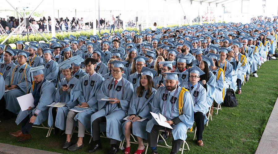 Hundreds of GS graduates in blue gowns seated under the tent at the Class Day ceremony