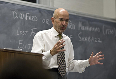 Dean Peter J. Awn lectures in front of a large chalkboard