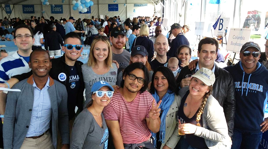 GS students and alumni pose under the tent at Columbia Homecoming