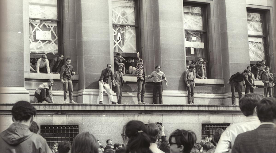 Students stand in windowsills and on ledges, protesting