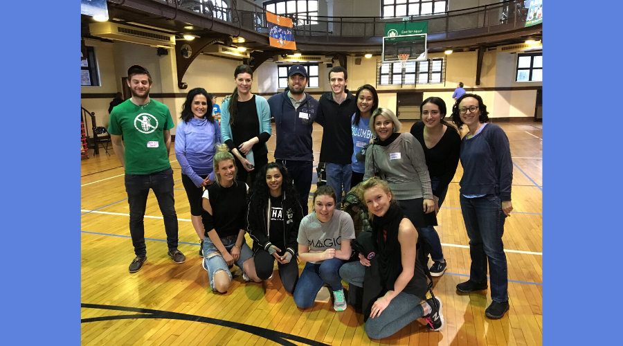 GS student Rachel Adams stands on the left end of a group of volunteers in a basketball court