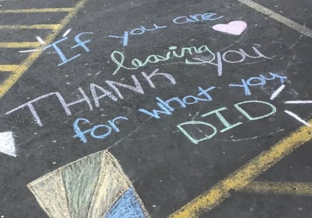 Thank-you message written in chalk on asphalt