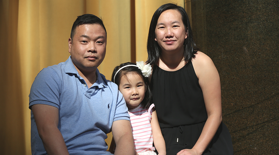 Postbac alumna Sheng Chow poses for a photo with her husband and daughter