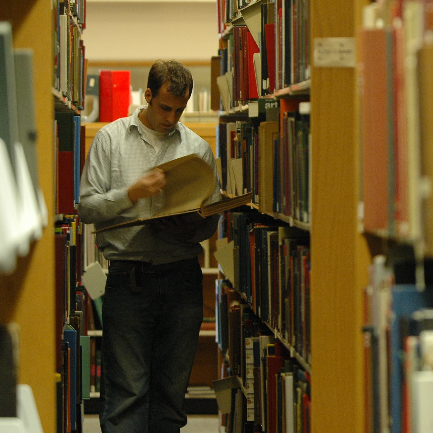 Student reading in Butler Library stacks.